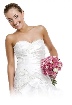 A smiling bride in a strapless gown holding a bouquet of pink and cream roses